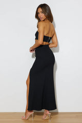 Slim-fitting black evening gown with side cutouts.